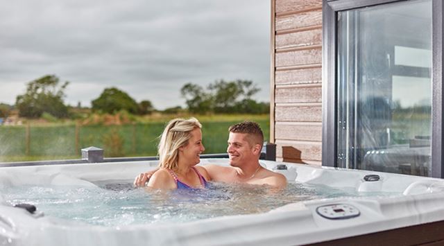A couple relaxing in their lodge hot tub