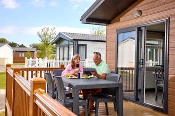 A couple enjoying lunch on their own lodge holiday home's veranda in Yorkshire