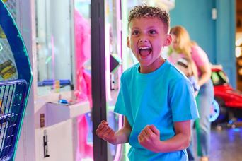 Little boy celebrating winning at the arcades