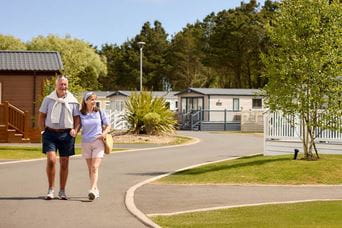 Couple holding hands walking through Parkdean Resorts