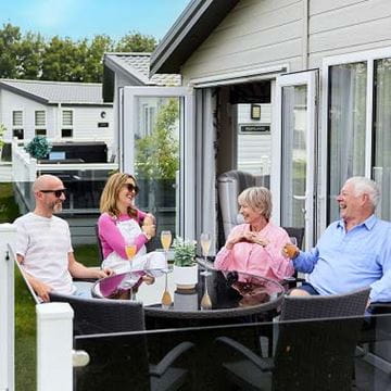 Family sat on veranda at Parkdean Resorts