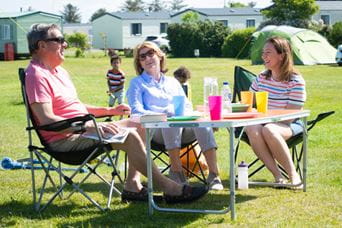 Friends sat on camp chairs at Parkdean Resorts