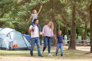 Family walking through woods holding hands