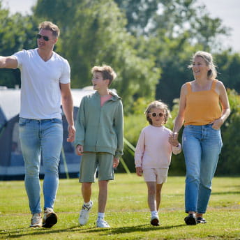 family holding hands walking around holiday park