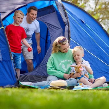 Family sat outside blue tent