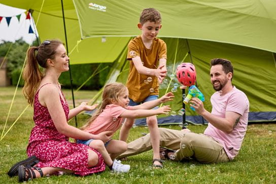 Family playing outside tents