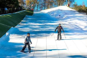 a child and an adult on a ski slope