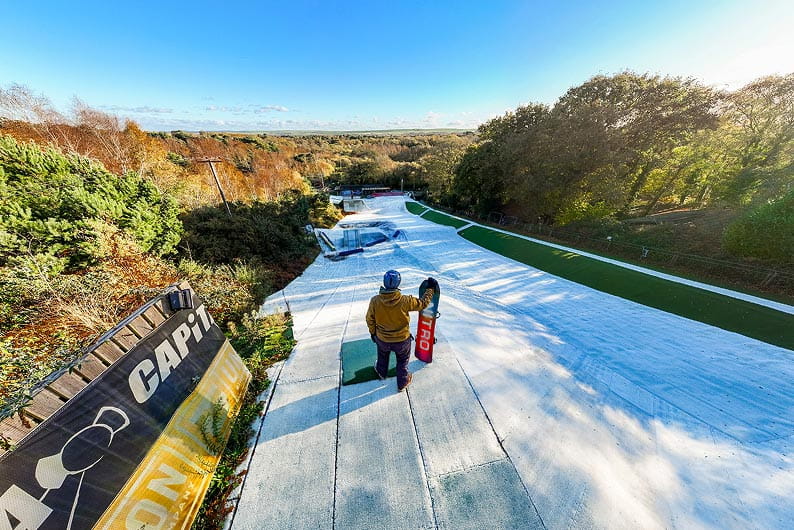 drone shot of a snowboarder standing on the ski slope