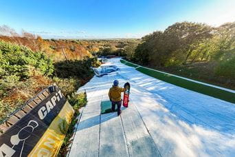 drone shot of a snowboarder standing on the ski slope