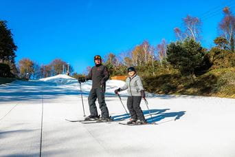 a child and an adult on a ski slope