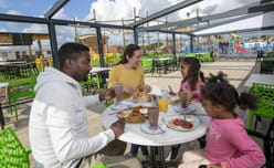 Family of four sat outside eating and drinking at Parkdean Resorts