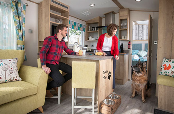 Couple and their dog inside a pet friendly caravan