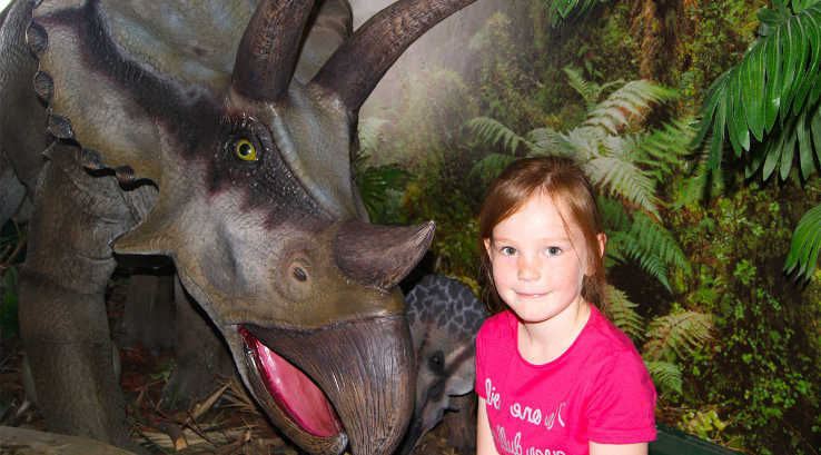Little girl with a model triceratops at Torquay Dinosaur World