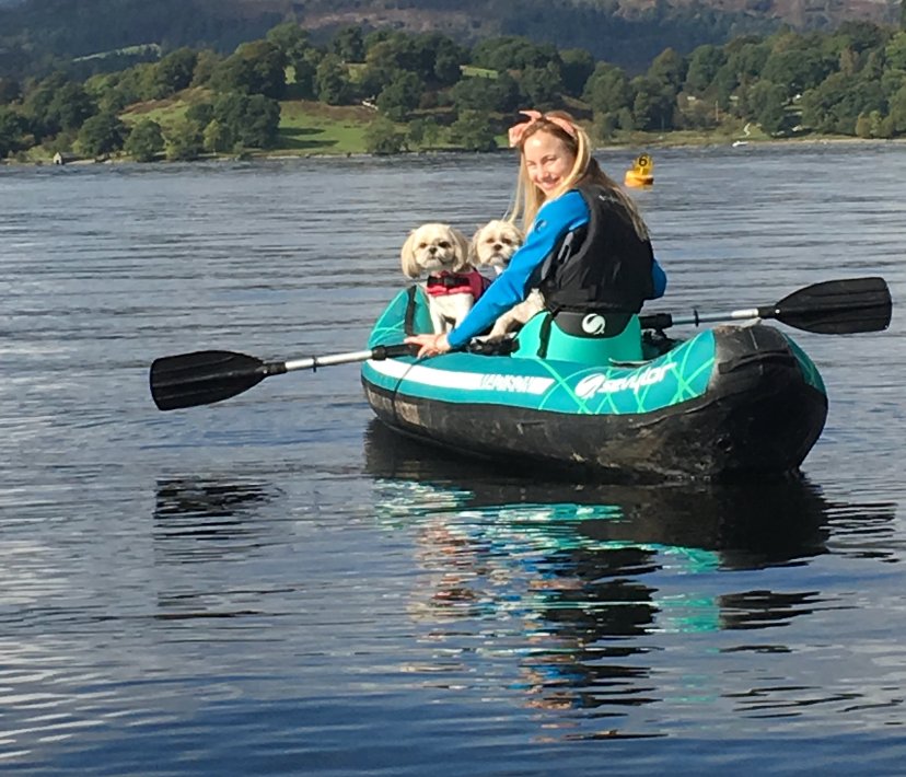 Woman and her dogs kayak on water
