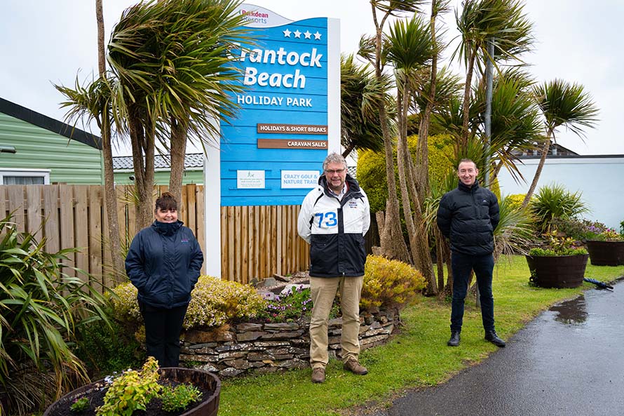 The general manager and local MPs posing for a photo at the entrance to Crantock Beach Holiday Park in Cornwall