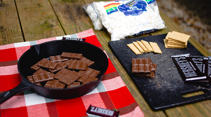 Chocolate in a frying pan and chopping board on top of a picnic blanket