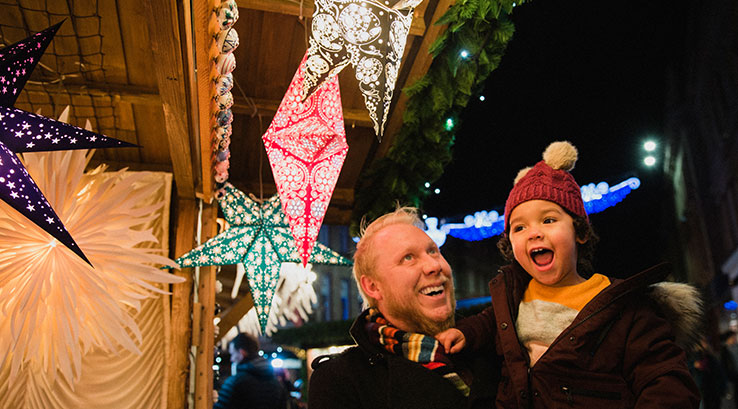 A father and sun enjoying christmas decorations at a christmas market
