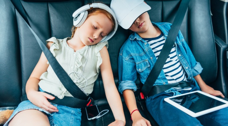 Children asleep on family road trip