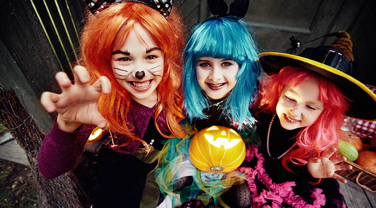 Three young girls in Halloween fancy dress costumes