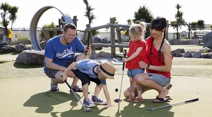 A family playing crazy golf at Trecco Bay Holiday Park