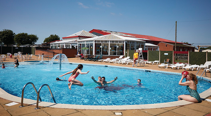 Families enjoying the outdoor swimming pool at Cherry Tree Holiday Park