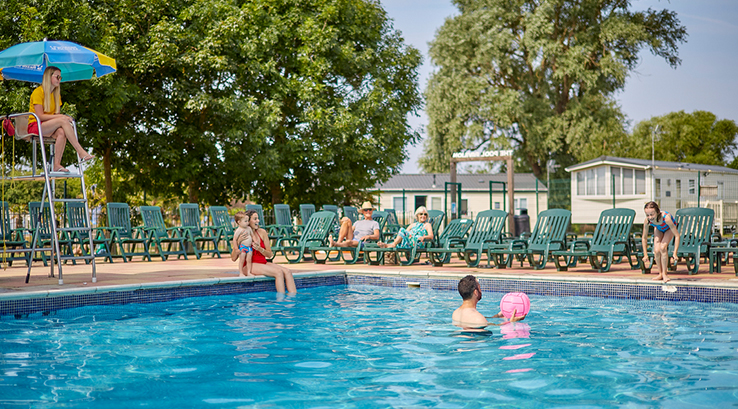 A family enjoying the outdoor swimming pool at Highfield Grange Holiday Park