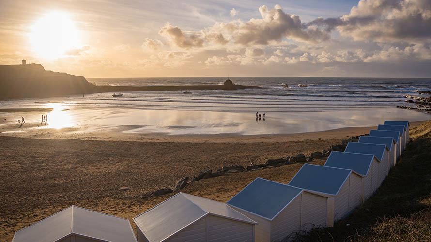 Sunset over Summerleaze Beach and its row of beach huts