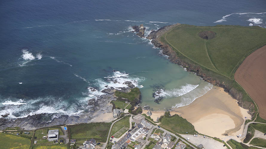 An aerial view of Trevone Bay, with Round Hole visible on the headland behind