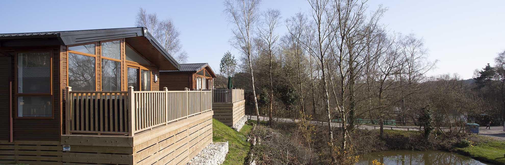 Two luxury lodges overlooking the fishing lake at Warmwell Holiday Park in Dorset