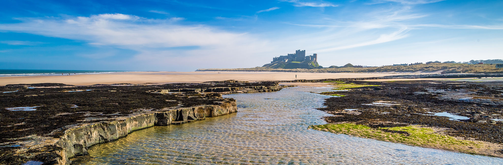 A view of Bamburgh Beach in Northumberland with Bamburgh Castle in the distance