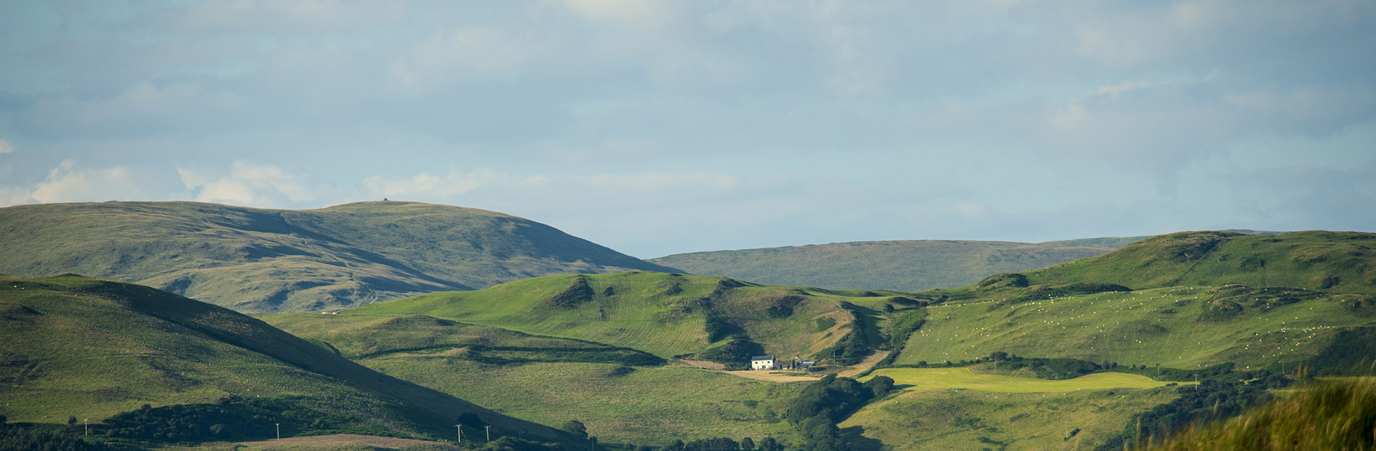 A landscape shot of rolling green hills in the Welsh countryside