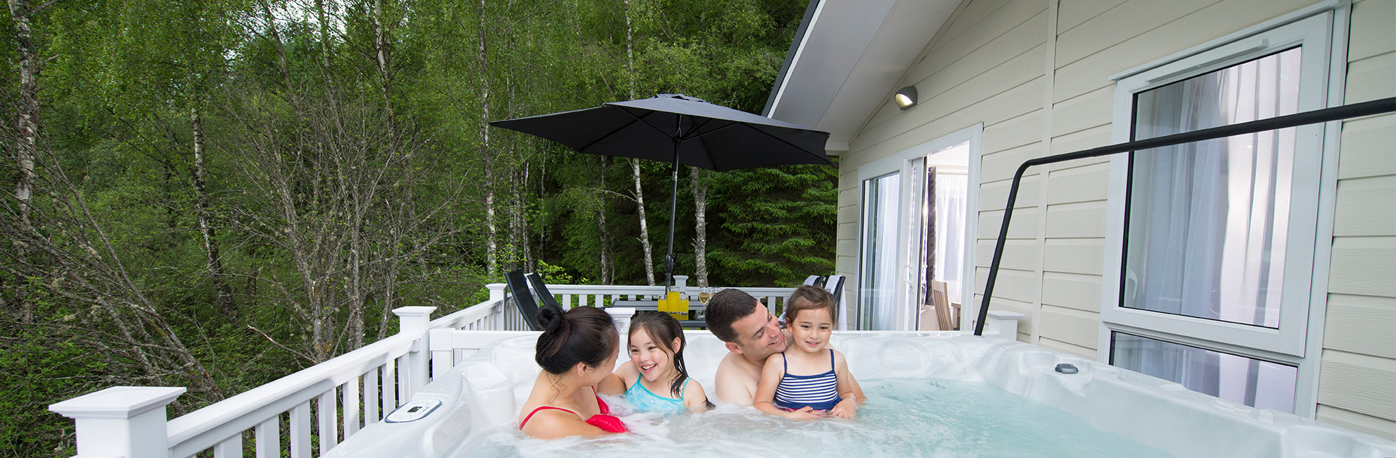 A family enjoying the hot tub of their lodge