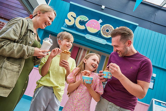 A family enjoying ice cream outside a Scoops ice cream parlour 