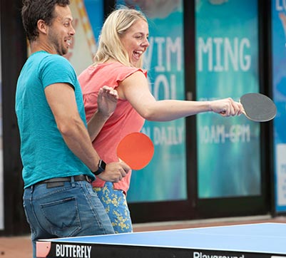 A couple playing outdoor table tennis
