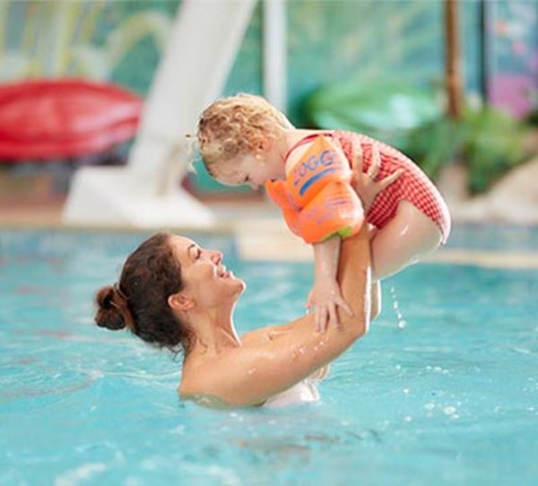 A mother and her little girl playing in the indoor pool