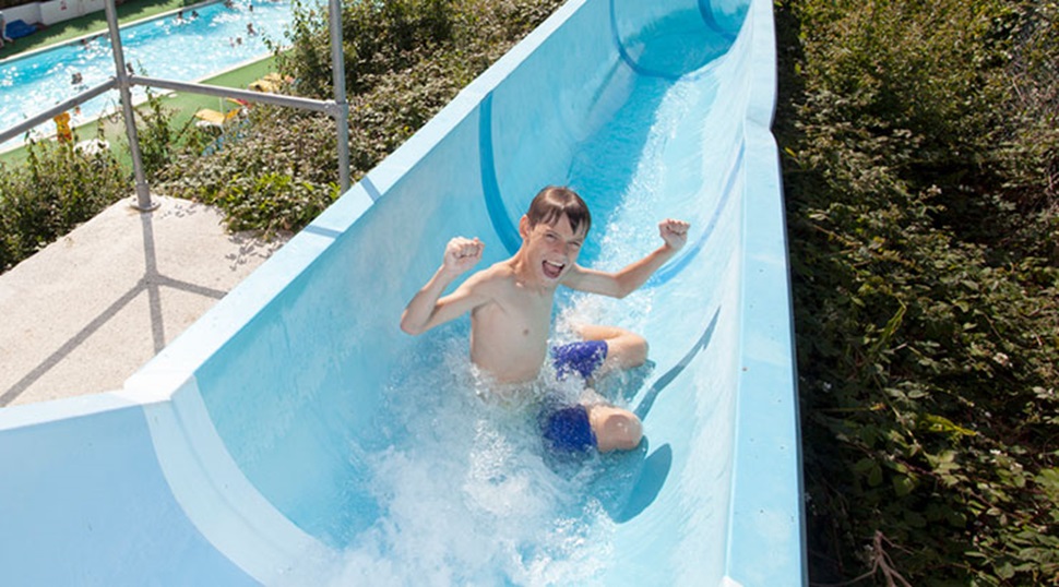 A boy sliding down an outdoor water slide