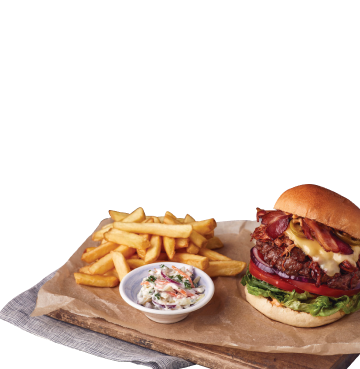 Cheeseburger and chips and coleslaw on a wooden board