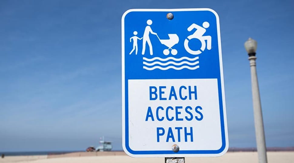 An accessible beach access path signpost on a beach