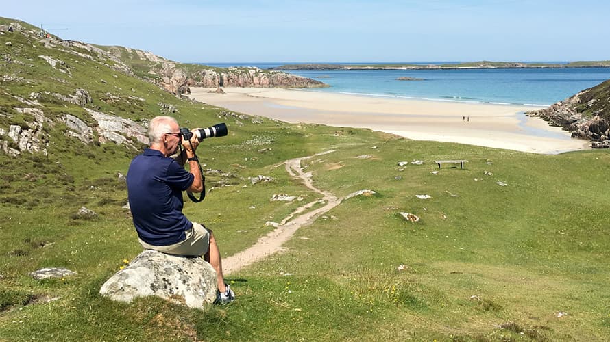 A man photographing a beach in Scotland