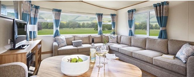 The interior of a modern caravan living room with views of the countryside