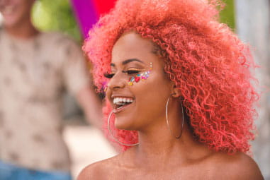 woman with pink hair and face gems at a festival