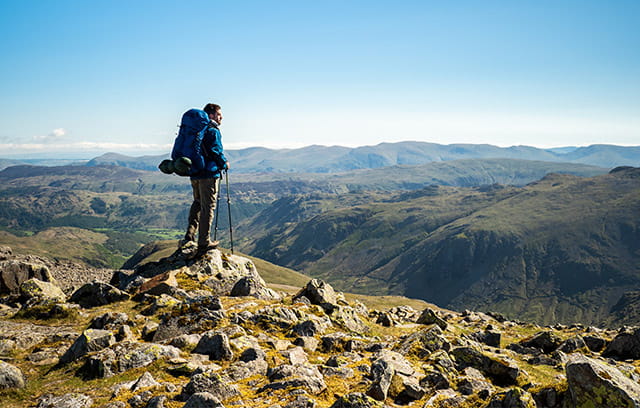 A solo mountain hiker enjoying a view of the Lake District