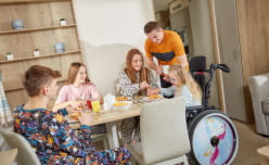 A family having a meal together in an accessible caravan