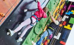 Two people in harnesses climbing