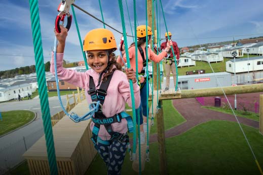 Little girl walking on the high ropes at Parkdean Resorts