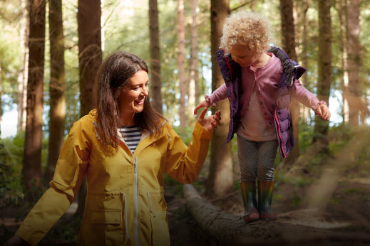 Mum holding daughters hand in the woods