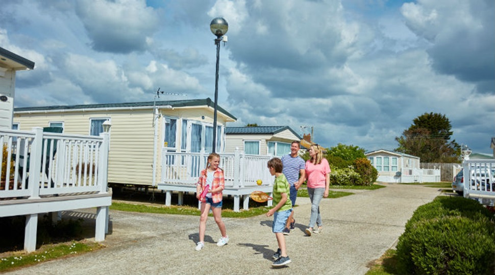 A family exploring the park by the caravans at Romney Sands Holiday Park