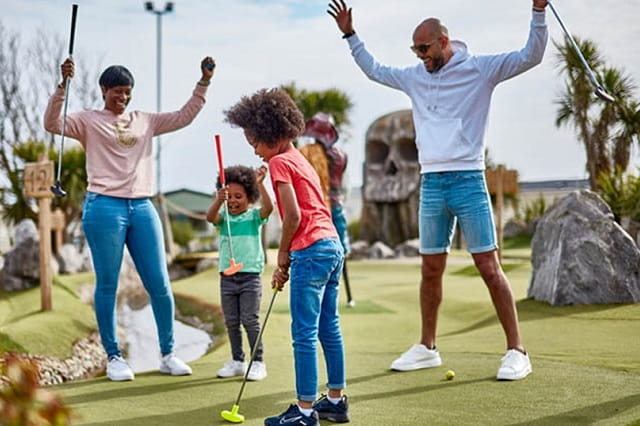 A family playing crazy golf at Trecco Bay