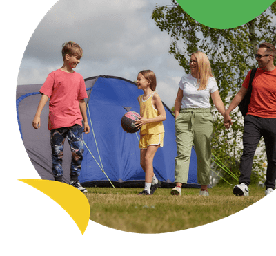 A family walking past their tent at Vauxhall Holiday Park