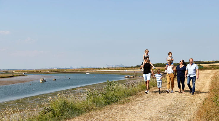 A family stroll along the coastal path by the beach on a sunny day